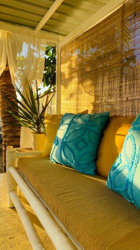 a couch with blue pillows sitting on a porch at The Beach House at Elyu Exclusive Beach Front Villa in Bauang
