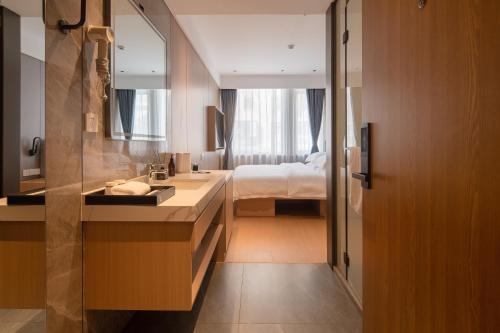 a bathroom with a sink and a bed in a room at Dayin Youth Hostel - Old Town & People's Square& Rail Hub -Social Area -Bar -Café -Gym -Free Laundry Luggage Storage -24H Front Desk -English Service in Shanghai