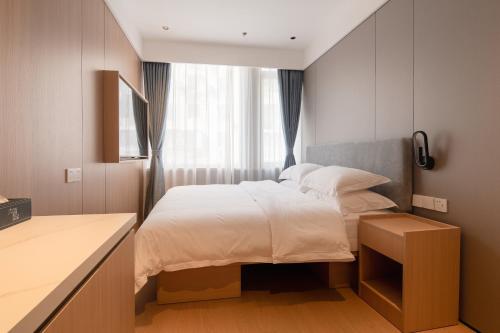 a small bedroom with a bed and a window at Dayin Youth Hostel - Old Town & People's Square& Rail Hub -Social Area -Bar -Café -Gym -Free Laundry Luggage Storage -24H Front Desk -English Service in Shanghai