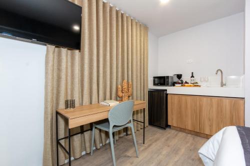a room with a desk and a kitchen with a table at Barcelo Coliving in Medellín