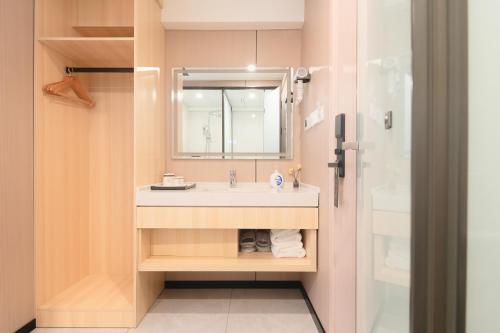a bathroom with a sink and a mirror and a shower at Dayin Youth Hostel - Old Town & People's Square& Rail Hub -Social Area -Bar -Café -Gym -Free Laundry Luggage Storage -24H Front Desk -English Service in Shanghai