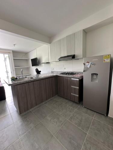 an empty kitchen with a refrigerator and a sink at Aqualina Green in Girardot