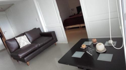 a living room with a black leather couch and a table at Alta vista in El Calafate