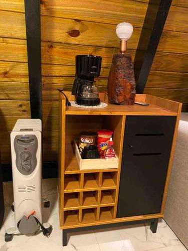 a small cabinet with a coffee maker and a blender at Magnífico Chalé Aconchego Serrano in Urubici