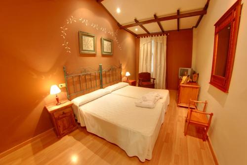 a bedroom with a large white bed in a room at Balneario San Andres in Canena