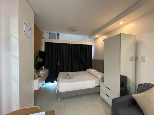 a bedroom with a bed and a cabinet and a television at Prima at Primavera City, CDO in Cagayan de Oro