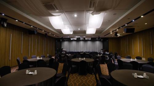 a conference room with tables and chairs and a stage at Grabel Hotel Jeju in Jeju