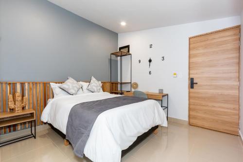 a bedroom with a large bed and a wooden door at Barcelo Coliving in Medellín