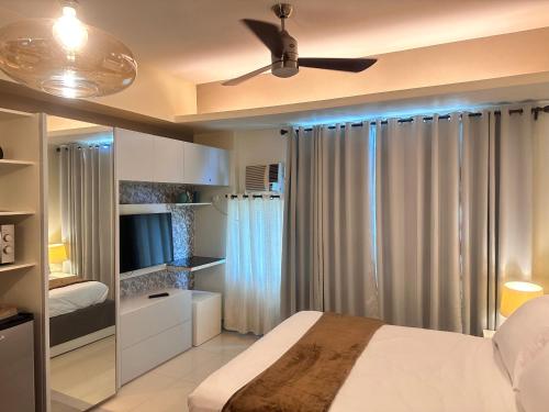 a bedroom with a bed and a ceiling fan at COZY COVE at Stamford Executive Residences in Manila