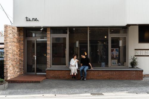 a man and a woman sitting outside of a building at tune HIGORO in Tateyama