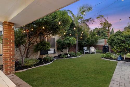 a backyard with a lawn with lights and trees at Town Central, walk to the beach in Busselton