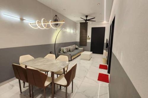a dining room with a table and chairs and a couch at Live Like Your Home, Alma Bukit Mertajam in Bukit Mertajam