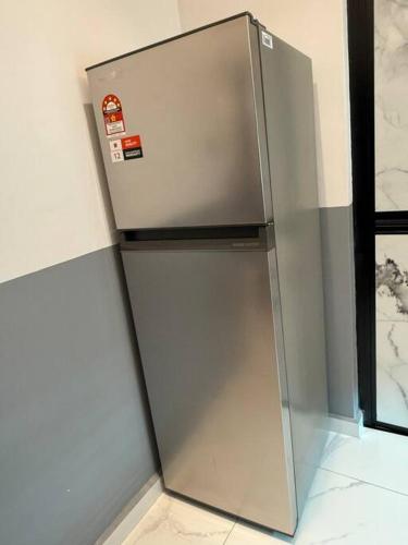 a stainless steel refrigerator in the corner of a room at Live Like Your Home, Alma Bukit Mertajam in Bukit Mertajam