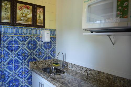 a kitchen with a sink and a microwave at Pousada Terê Parque in Teresópolis
