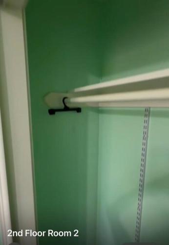 a room with a green wall and a door with a rod at Casa Colibrí in Harlingen