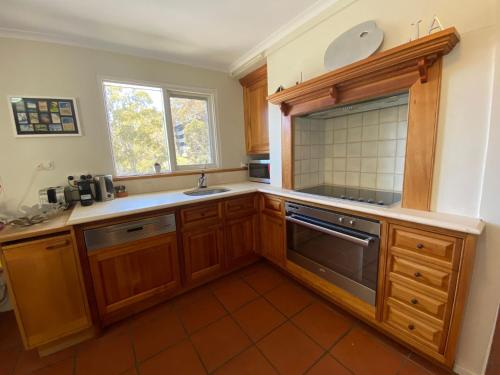 a kitchen with wooden cabinets and a sink and a window at Inala 3 - Thredbo in Thredbo