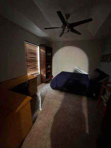 a bedroom with a bed and a ceiling fan at Casa Colibrí in Harlingen