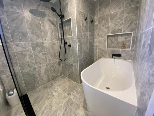 スレッドボにあるInala 3 - Thredboのシャワー、浴槽、洗面台を備えたバスルーム