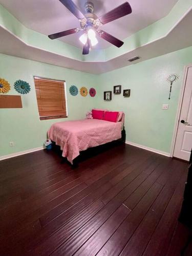 a bedroom with a bed and a ceiling fan at Casa Colibrí in Harlingen