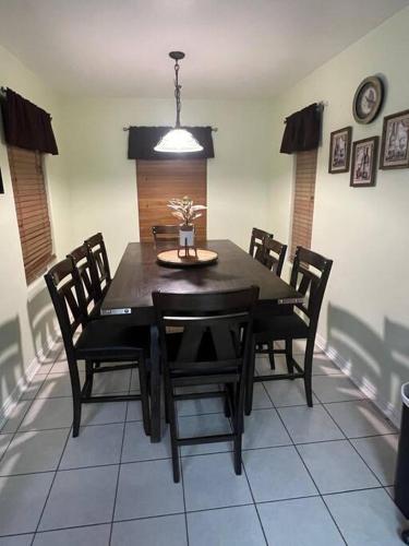 a dining room with a black table and chairs at Casa Colibrí in Harlingen
