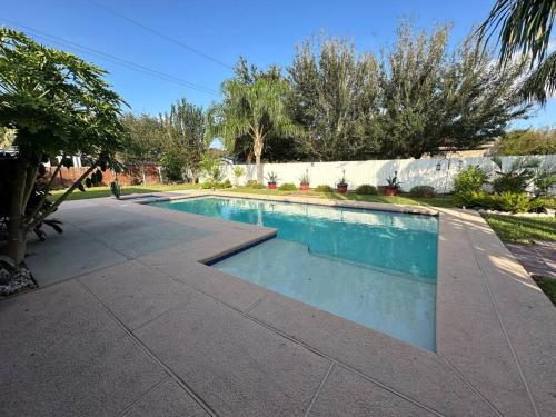 a swimming pool with blue water in a yard at Casa Colibrí in Harlingen
