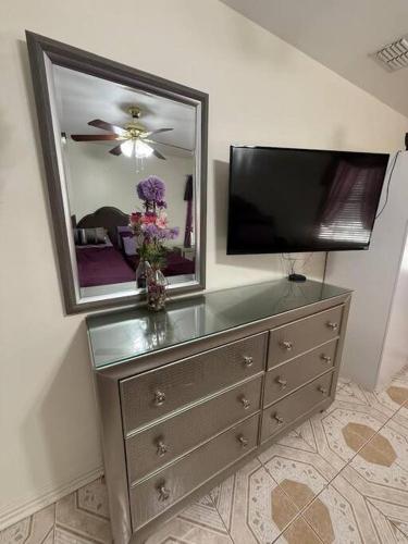 a dresser with a mirror and a television on it at Casa Colibrí in Harlingen