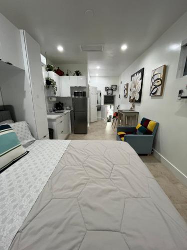 a bedroom with a large white bed and a kitchen at Luna y Sol Calle 8 in Miami