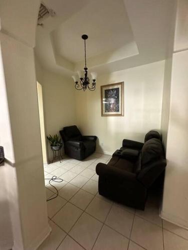 a living room with a couch and a chandelier at Casa Colibrí in Harlingen