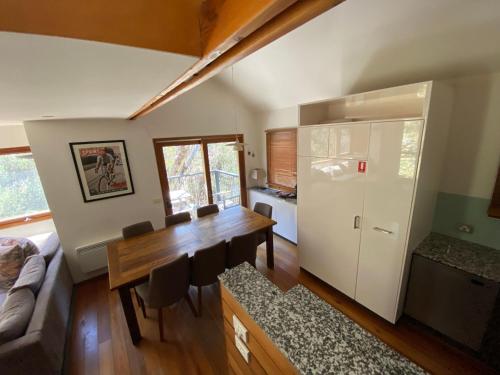 a living room with a dining room table and a kitchen at Ramshead Creek 3 - Thredbo in Thredbo