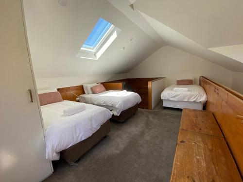 a attic room with two beds and a window at Ramshead Creek 3 - Thredbo in Thredbo