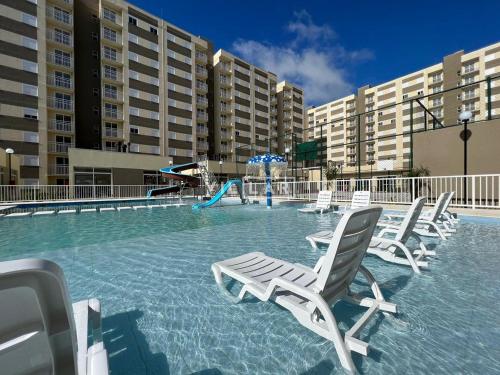 a swimming pool with chairs and a slide at Apto 5 Estrelas no Centro de Pelotas in Pelotas
