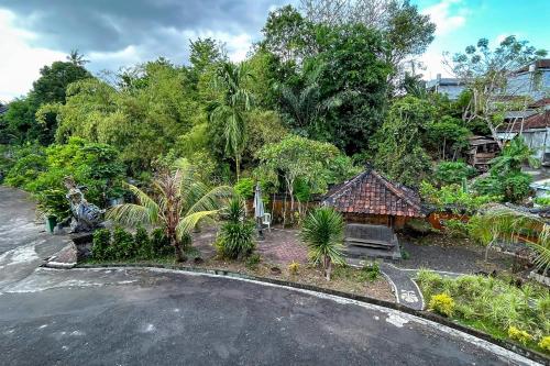 a house with a lot of trees and a driveway at Batukaru Garden Hotel Ubung Denpasar in Kesiman