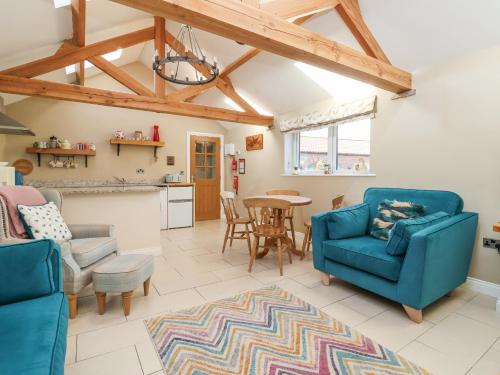 a living room with two blue chairs and a table at The Stables in Great Driffield