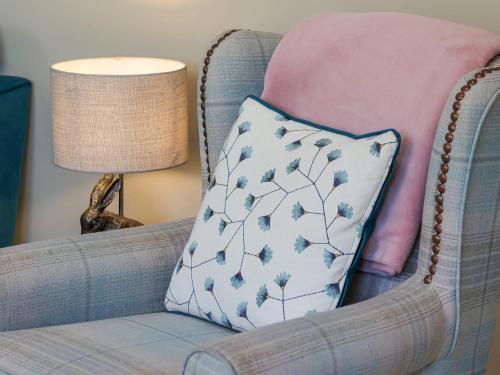 a pillow sitting on a chair with a lamp at The Stables in Great Driffield