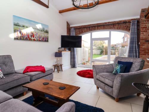 a living room with a couch and chairs and a table at Kingfisher Corner in Great Driffield