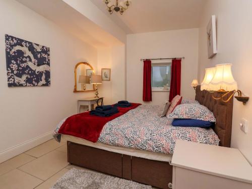 a bedroom with a bed and a red curtain at Kingfisher Corner in Great Driffield