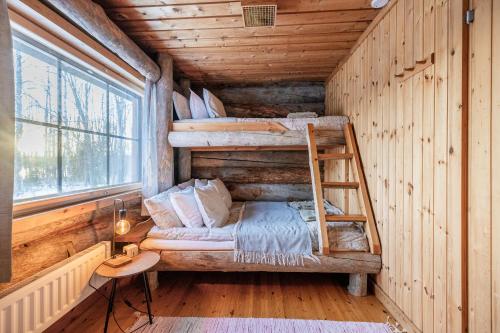 a room with two bunk beds in a log cabin at The Haven of Riverside - Villa Sieripirtti in Rovaniemi