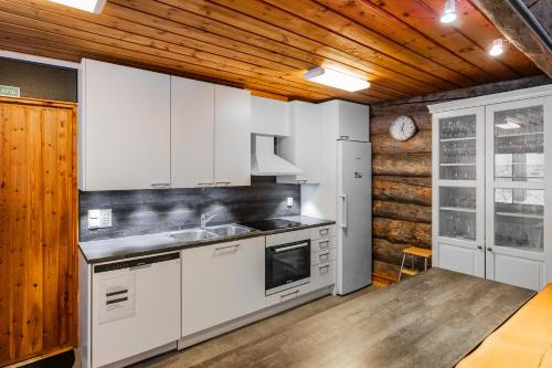 a kitchen with white appliances and a wooden ceiling at The Haven of Riverside - Villa Sieripirtti in Rovaniemi