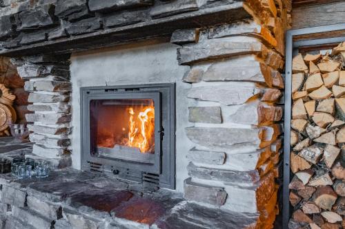 a stone fireplace with a fire in it at The Haven of Riverside - Villa Sieripirtti in Rovaniemi