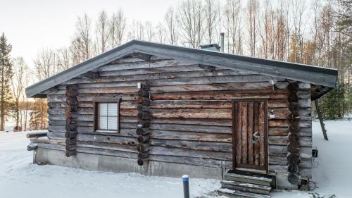 a log cabin with a door in the snow at The Haven of Riverside - Villa Sieripirtti in Rovaniemi