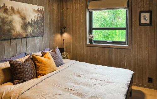 a bedroom with a bed with pillows and a window at Awesome Home In Rauland With Sauna in Rauland