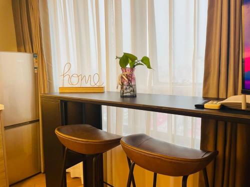 a desk with two chairs and a vase with a plant at Shanghai Lerongju Boutique Apartment Metro Line 8 20meter in Shanghai