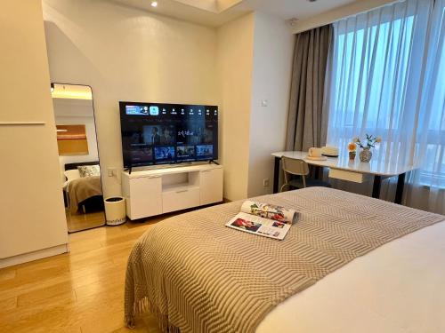a hotel room with a bed and a flat screen tv at Shanghai Lerongju Boutique Apartment Metro Line 8 20meter in Shanghai