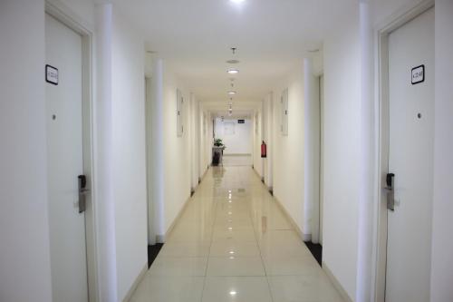 a corridor of a building with white walls and a long hallway at Urban Hotel Serpong in Banten