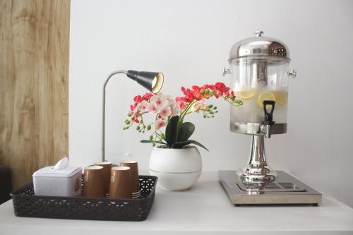 a table with a blender and a vase with flowers at Urban Hotel Serpong in Banten