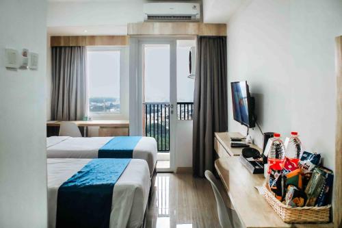 a hotel room with a bed and a television at Urban Hotel Serpong in Banten