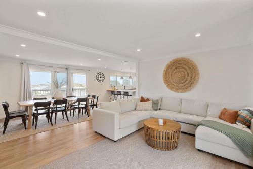 a living room with a white couch and a table at The Beach House 64 Neighbour Ave Goolwa Beach - No Linen Included in Goolwa