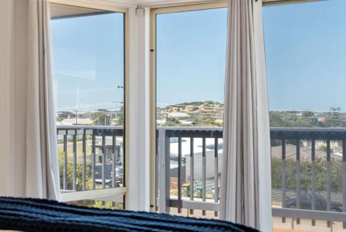 a bedroom with windows with a view of the ocean at The Beach House 64 Neighbour Ave Goolwa Beach - No Linen Included in Goolwa