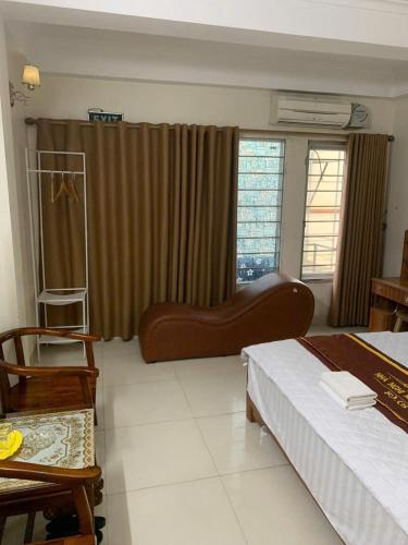 une chambre avec un lit, un canapé et une chaise dans l'établissement Minh Thành Hotel Hà Đông HN - by BAY LUXURY, à Dại Mõ