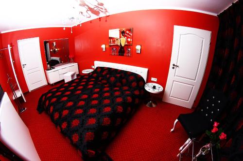 a red bedroom with a large bed and a bathroom at Kardamon in Żary